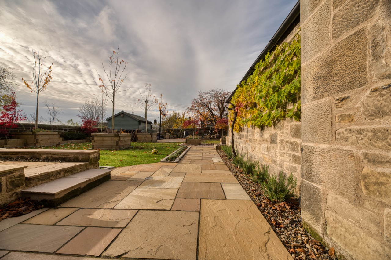 Professional buff Indian sandstone patio installation in Edinburgh garden with traditional character and natural warm tones