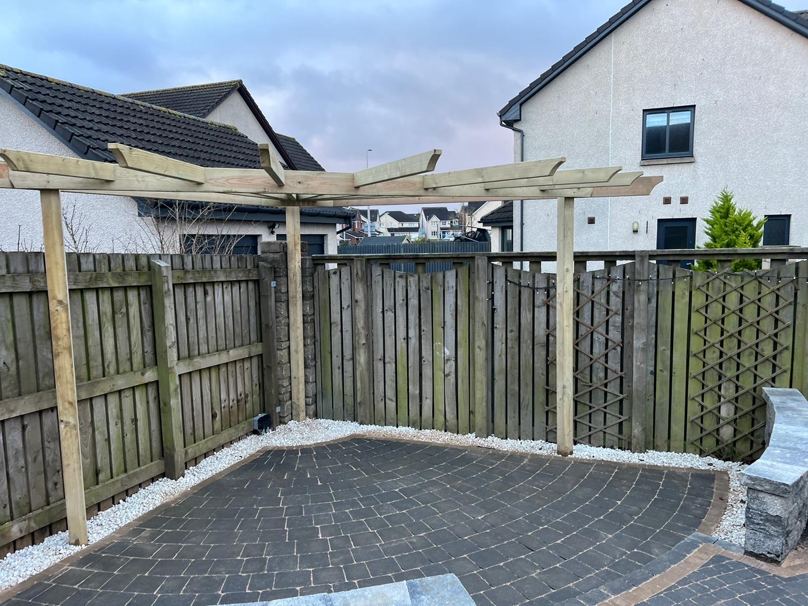 Custom timber pergola installation with integrated paving in modern Kirkliston property