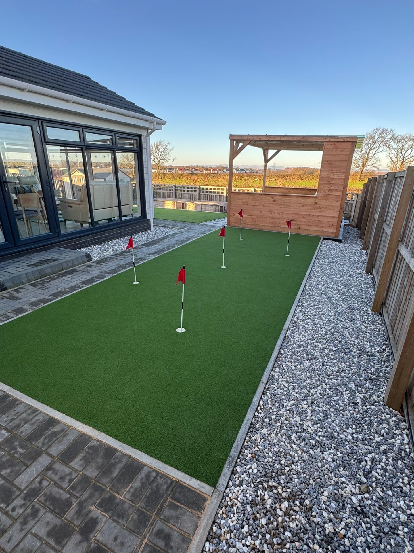 Modern pergola with artificial grass putting green in family garden near Kirkliston Primary