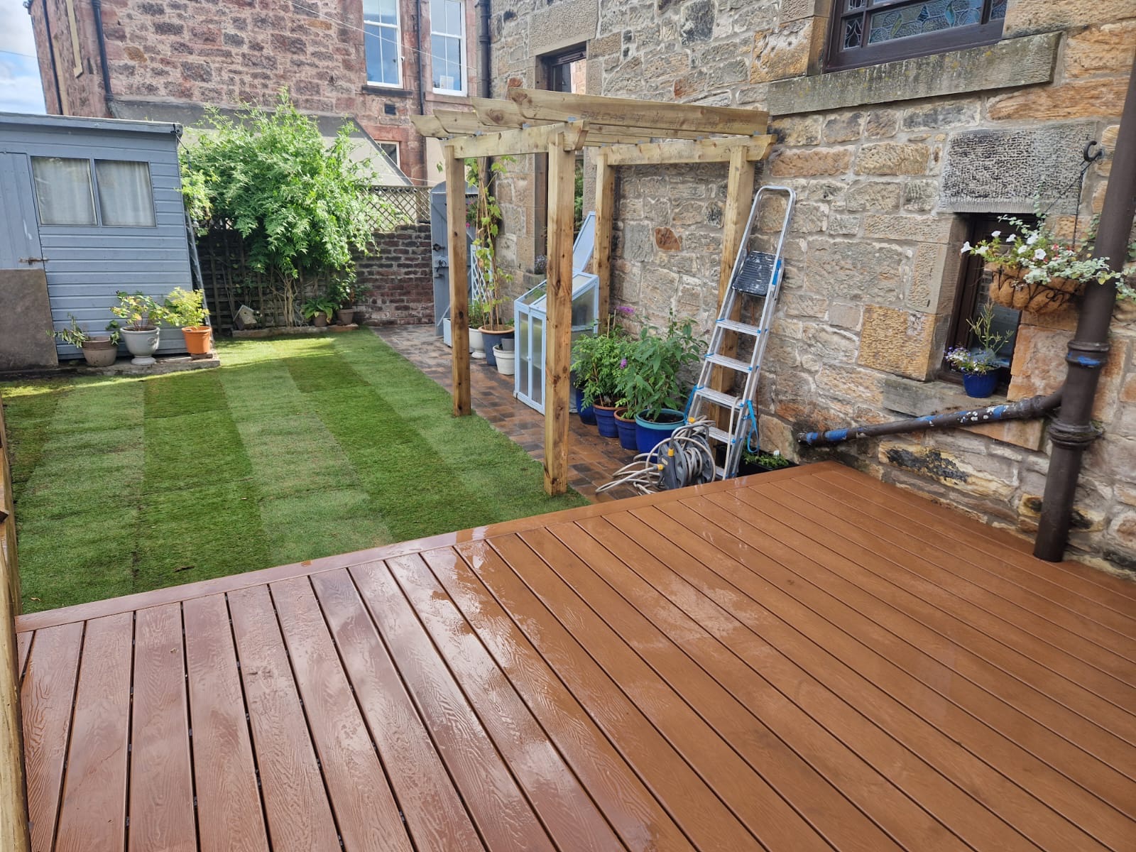 Timber pergola installation with composite decking in Edinburgh stone garden