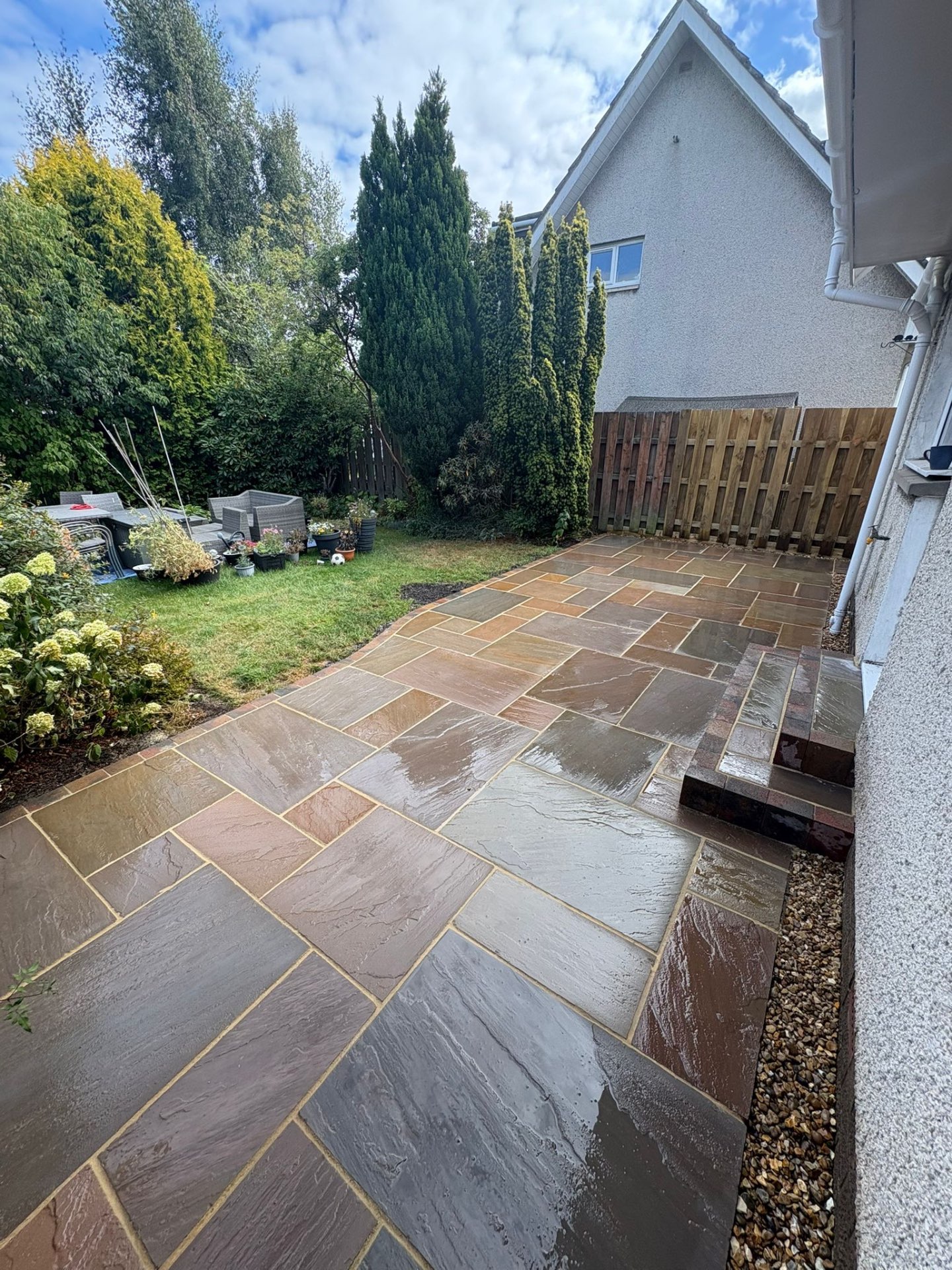 Buff Indian sandstone patio with modern garden design and artificial grass in Winchburgh EH52