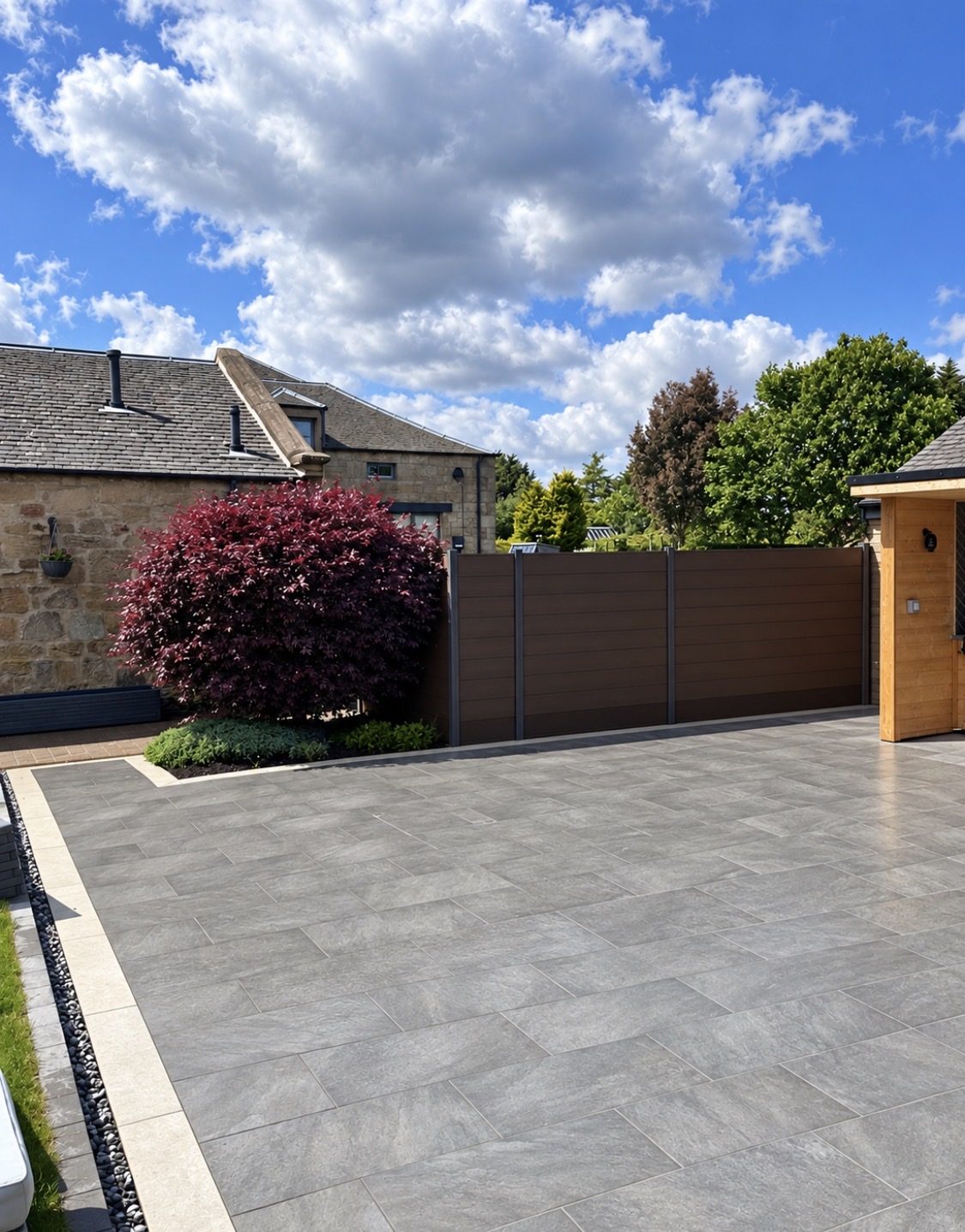 Modern composite fence panels with grey frames screening a garden and porcelain driveway