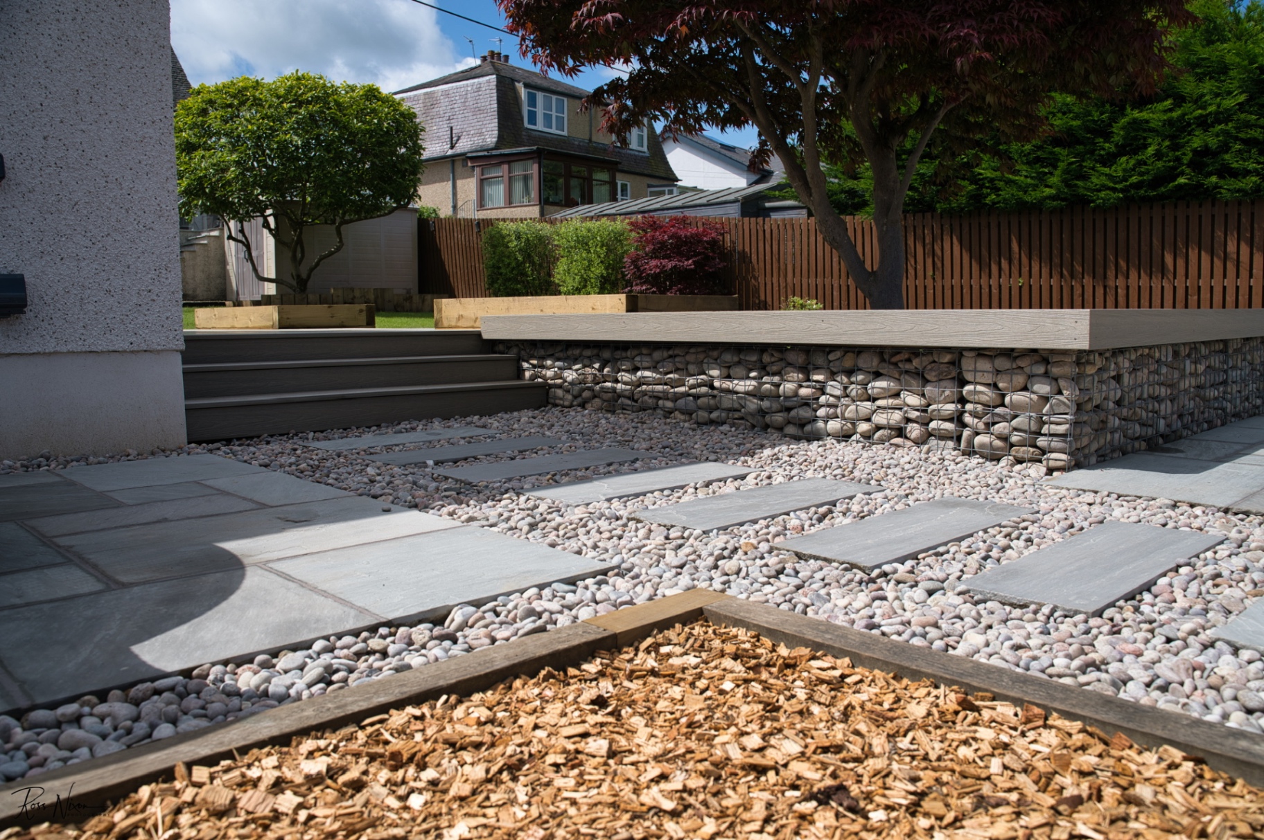 Contemporary garden design with gabion walls and composite decking in Scottish property