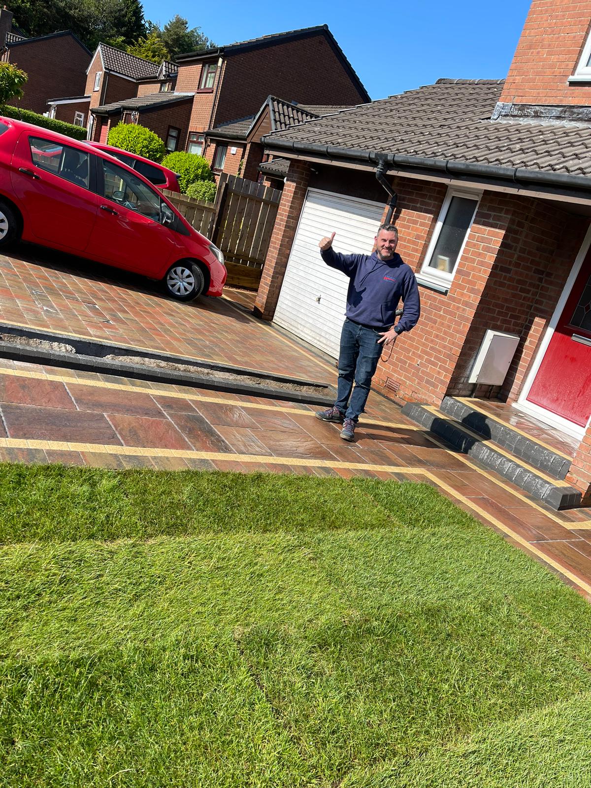 Maybury Landscaping team member with completed driveway transformation in Edinburgh