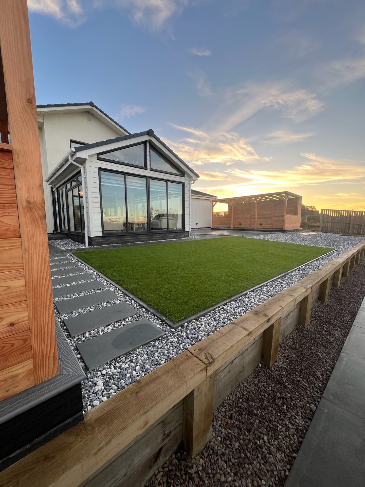 Contemporary Edinburgh garden design featuring modern garden room, porcelain paving, and premium artificial grass creating year-round outdoor living space