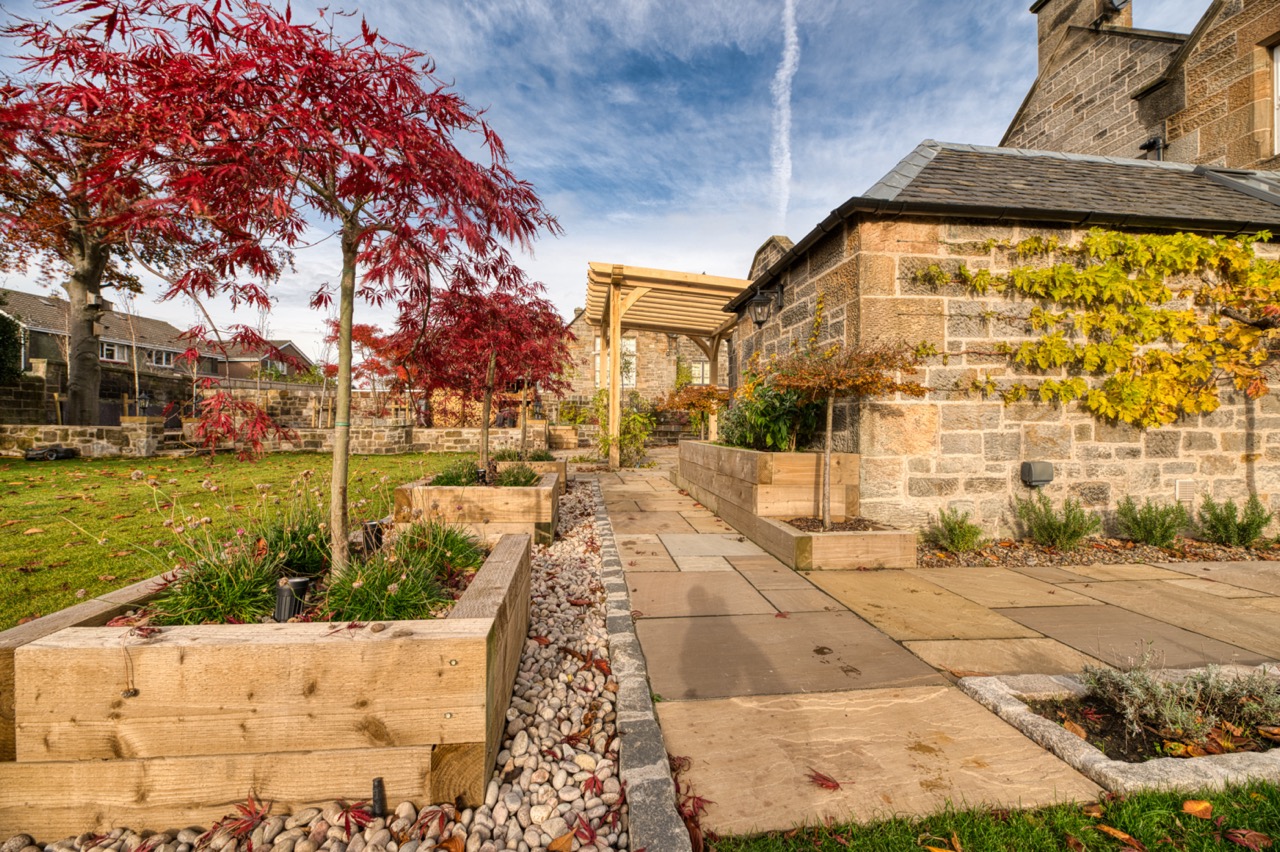 Heritage garden with sandstone paving oak planters and timber pergola