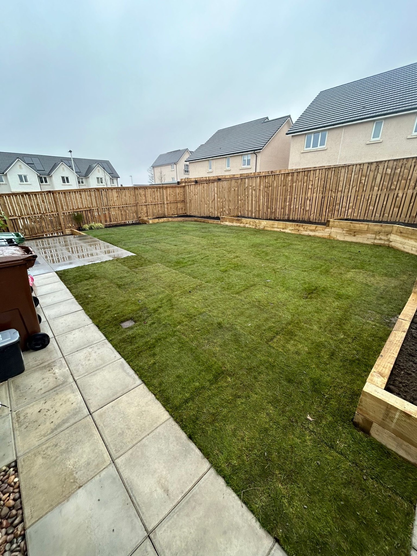 Newly landscaped Scottish garden with fresh turf installation and timber raised beds after professional drainage correction