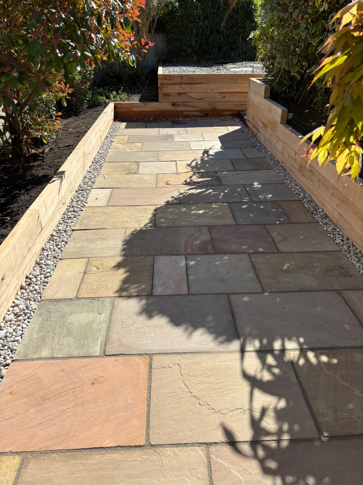 Paved garden path with Indian sandstone and timber raised beds in Scottish residential garden