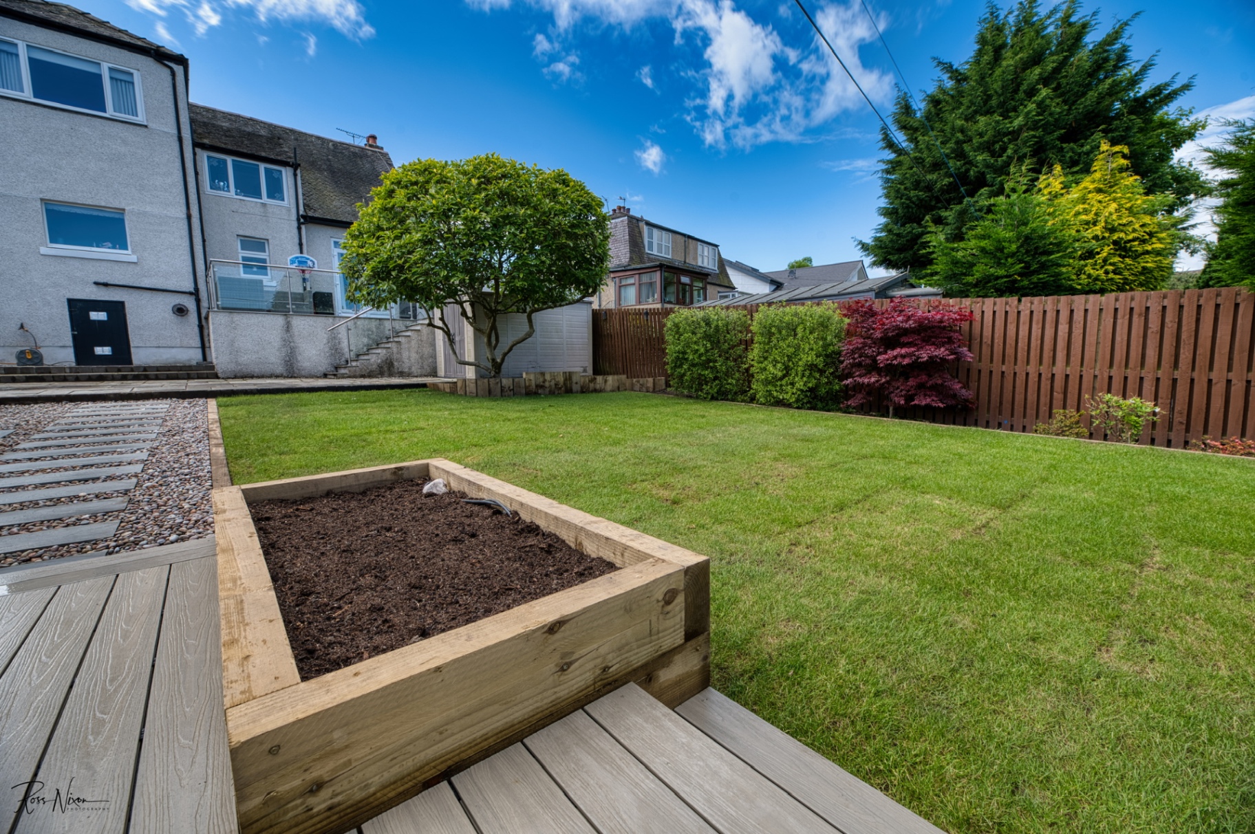 Spacious Scottish garden with timber raised bed walls and composite decking installation