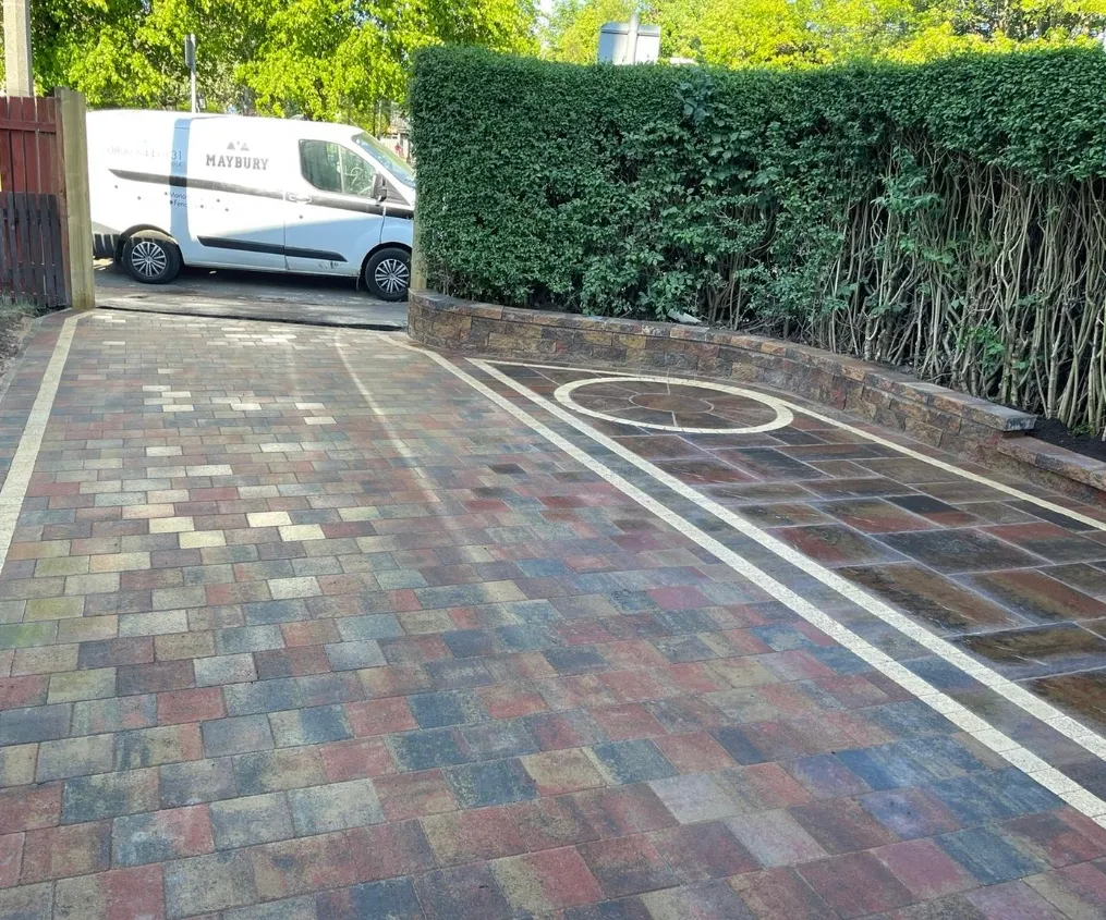 "Alt text: A visually striking Tobermore Heather Shannon driveway, expertly installed on Stevenson Drive in Edinburgh. The driveway features a beautiful arrangement of Heather Shannon paving stones, creating a captivating pattern that adds elegance and character to the entrance of the property. The deep, rich colors of the paving stones complement the surrounding landscape, while the precise installation ensures a durable and functional surface for vehicles. The attention to detail in this driveway installation showcases the craftsmanship and expertise of the professionals involved, making it a standout feature of the property."